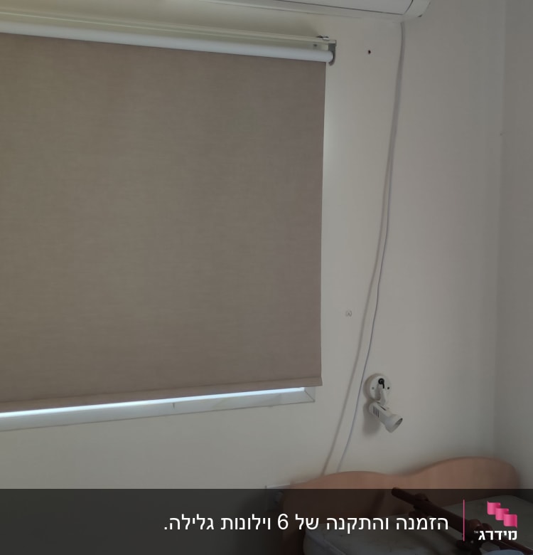וילון גלילה חום על חלון בחדר שינה